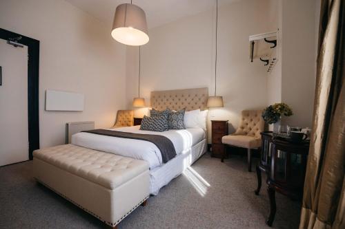 een slaapkamer met een groot bed en een stoel bij Hotel Etico at Mount Victoria Manor in Mount Victoria