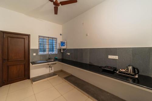 a kitchen with a counter and a sink and a door at FTP (French Town Palacial) in Puducherry