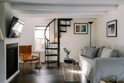 a living room with a spiral staircase and a couch at The Roundtree, Amagansett in Amagansett
