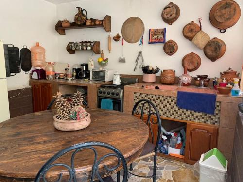 eine Küche mit einem Holztisch, einem Tisch und einem Herd in der Unterkunft Finca MacNoy Casa 12 personas Ixmiquilpan,Hgo cerca balnearios y Tolantongo in Ixmiquilpan