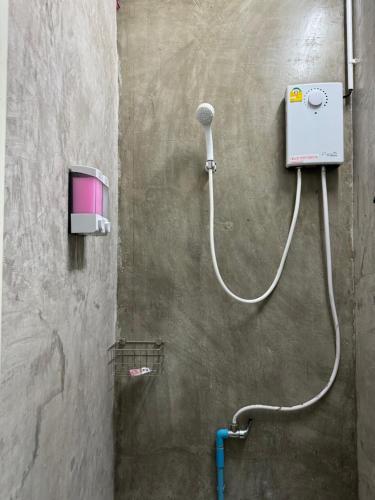 a shower with a hose attached to a wall at Baan Chiang Maan in Chiang Mai