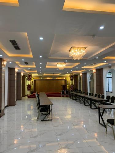 um salão de banquetes com cadeiras e um palco num edifício em Hoa Hồng Hotel Sơn La em Sơn La