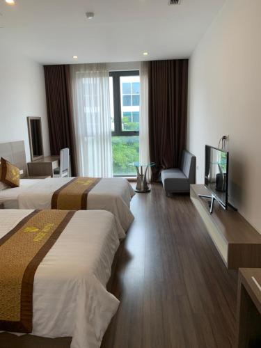 a hotel room with two beds and a flat screen tv at Hoa Hồng Hotel Sơn La in Sơn La
