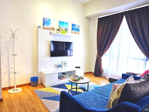 a living room with a blue couch and a tv at HomeZz Imperium Residence Kuantan Studio Seaview in Kuantan