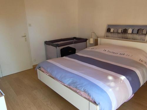 une chambre avec un grand lit dans une pièce dans l'établissement Maison familiale près de la mer avec terrasse et véranda, quartier calme à Saint Jean de Monts - FR-1-323-502, à Saint-Jean-de-Monts