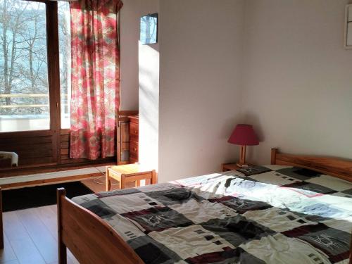 - une chambre avec un lit en face d'une fenêtre dans l'établissement Charmant 2 pièces avec balcon, proche village et navettes, pour 4-6 personnes - FR-1-761-37, à Villard-de-Lans