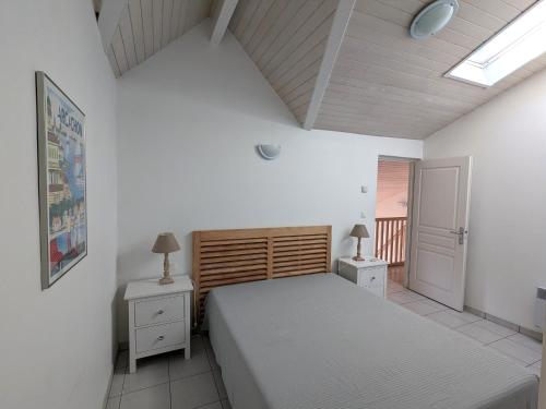 une chambre avec deux lits et deux tables de nuit dans l'établissement Duplex T3 lumineux à Arcachon avec balcon, parking, Wi-Fi à 5 min de la plage et des commerces - FR-1-420-140, à Arcachon