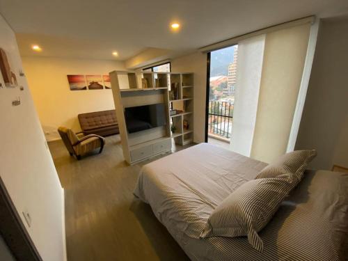 um quarto com uma cama e uma grande janela em Espectacular Loft en Bogotá! em Bogotá
