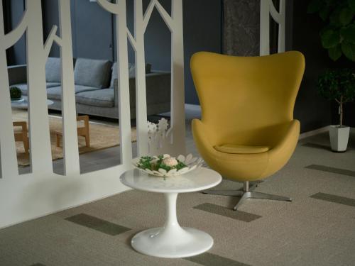 a living room with a yellow chair and a table at Holiday House Green Garden in Gujo