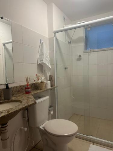 uma casa de banho com um chuveiro, um WC e um lavatório. em Apartamento em Condomínio Marinas Clube em São Pedro da Aldeia