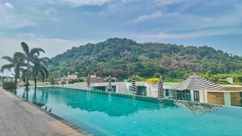 a swimming pool with a mountain in the background at Twin Sands Resort Penthouse in Patong Beach