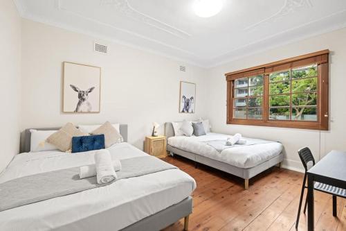 1 dormitorio con 2 camas y ventana en Quadruple Room in Gordon near Train & Bus Sleeps 4, en Pymble