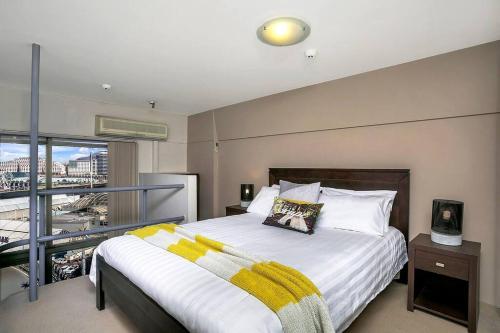 1 dormitorio con 1 cama grande y balcón en SX504 - Loftstyle One Bedroom in the Heart of CBD en Sídney
