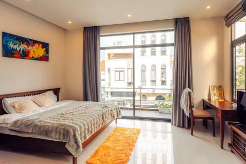 - une chambre avec un lit et une grande fenêtre dans l'établissement Sunset Pool Villa 4BR, New, Full AC, walk to beach, à Đà Nẵng