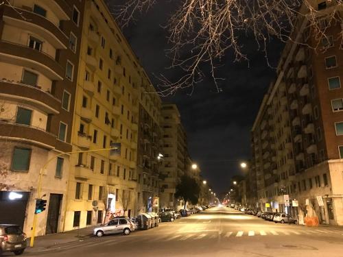 an empty city street at night with cars parked at pardis dormitory in Rome