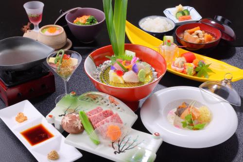 uma mesa coberta com pratos de comida numa mesa em Shikanoyu Hotel em Komono