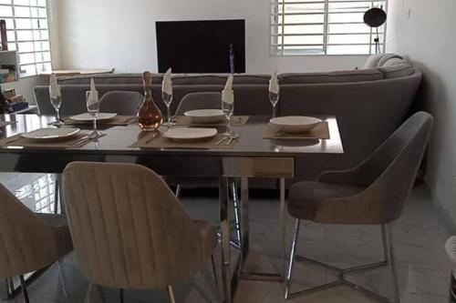 a dining room table with chairs and a couch at Chateau Eyram in Accra