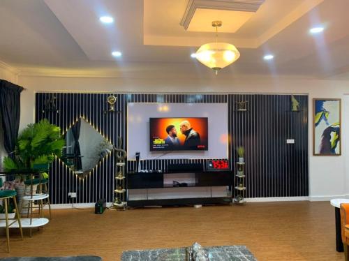 a living room with a flat screen tv on a wall at WATER VIEW 3 BEDROOM APARTMENT WITH JACUZZI PARKING WiFi NETFLIX POOL in Lekki