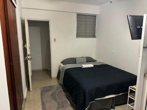 a bedroom with a bed with a black blanket at Economical Near Beach with Full bed 4th floor in San Juan