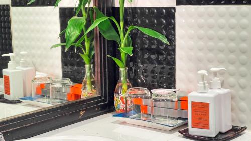 a bathroom counter with two bottles and a mirror at Siem Reap Urban Boutique Hotel in Siem Reap