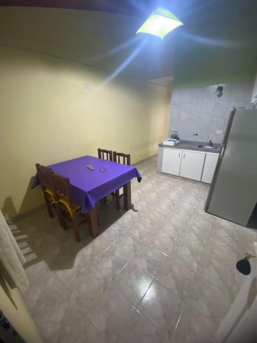 a kitchen with a purple table and chairs in a room at Alquileres y más in Villa Carlos Paz
