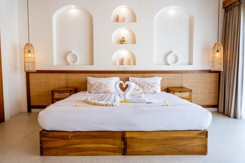 a bedroom with a large bed with white sheets at Shanti Boutique Retreat in Tanah Lot