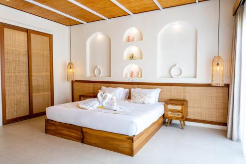 a bedroom with a large bed with white sheets at Shanti Boutique Retreat in Tanah Lot