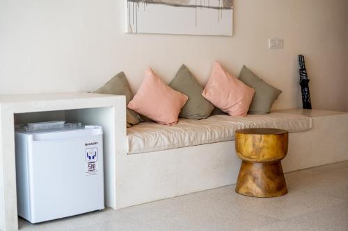 a couch with pillows on it and a wooden stool at Shanti Boutique Retreat in Tanah Lot