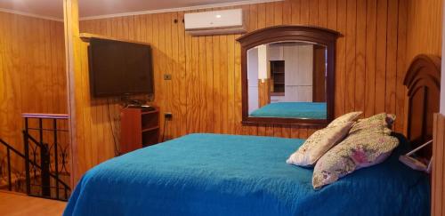 1 dormitorio con 1 cama con espejo y TV en Escapada romántica, en Pirque
