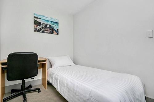 a bedroom with a desk and a bed and a chair at CBD Chinese Gardens Views, Modern 2BR Apt SX339 in Sydney