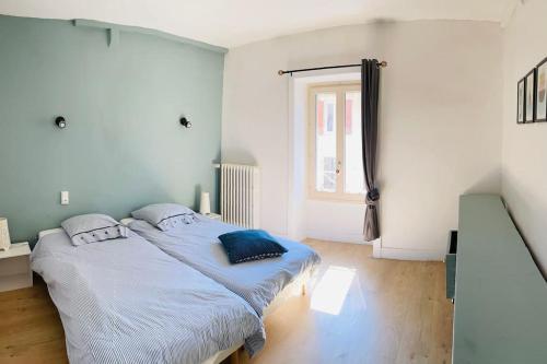 a bedroom with a bed with blue pillows on it at Gite Des Lacs Jumeaux in Clairvaux-les-Lacs