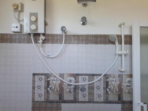 a bathroom with a shower with a hose on the wall at Southceylon77 in Weligama