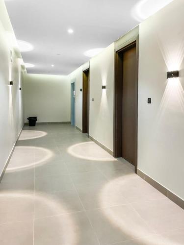 a hallway with white walls and white floors and lights at GR - A quiet bedroom apartment 10 in Riyadh