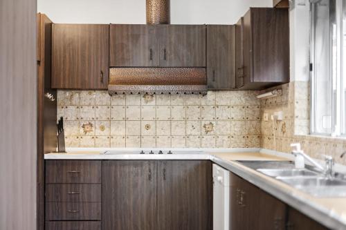 uma cozinha com armários de madeira e um lavatório em Premier Leichhardt Stayz em Sydney