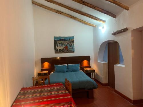 Un dormitorio con una cama y una mesa. en Hospedaje Killipata, en Cusco