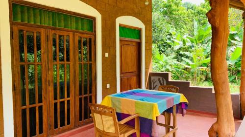 una camera con tavolo, sedie e finestra di Sigiriya Chena Villa a Sigiriya