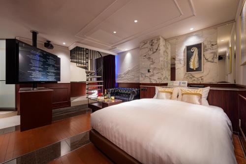 a bedroom with a large bed and a television at コスタリゾート茅ヶ崎大人専用 in Suka