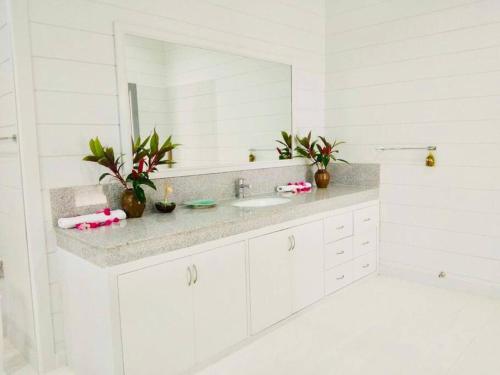 een witte badkamer met een wastafel en een spiegel bij The Sunny Hill Pool Villa 180° Panoramic Sea View 