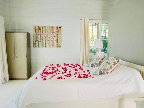 een wit bed met rode rozen erop bij The Sunny Hill Pool Villa 180° Panoramic Sea View 