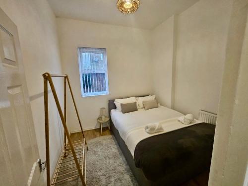 niewielka sypialnia z łóżkiem i oknem w obiekcie Large NEW House, Sleeps 10, FREE Parking, Near City Centre w Liverpoolu