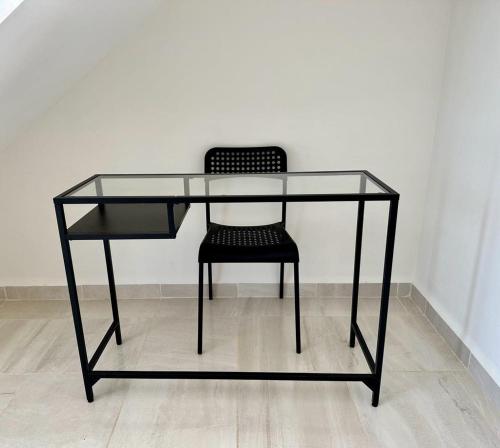 una scrivania di vetro con una sedia nera sotto di Alojamiento completo a San Isidro de los López