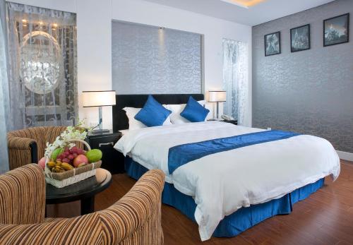 a bedroom with a bed and a bowl of fruit on a table at Victor Gallery hotel & spa - Victor Group in Hanoi