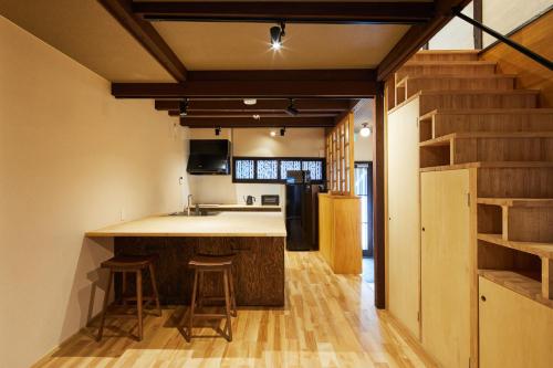a kitchen with a counter and stools in a room at Mibu Hanabusa House in Kyoto