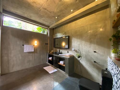 een badkamer met een wastafel en een tv aan de muur bij M60 Feet Villa in Madihe East