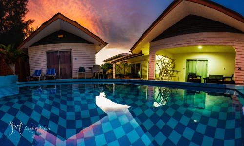 a swimming pool in front of a house at Hotel Plein Soleil in Grand Anse