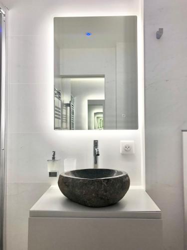 une salle de bain avec un lavabo en pierre et un miroir dans l'établissement Palm Beach apartment, à Cannes