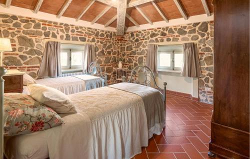 1 dormitorio con 2 camas en una habitación con paredes de piedra en 5 Bedroom Nice Home In Orentano, en Orentano