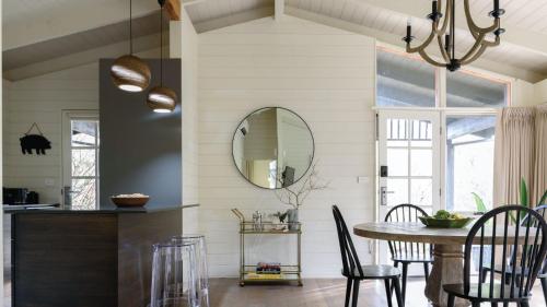 a dining room with a table and a mirror at Greenacres in Daylesford