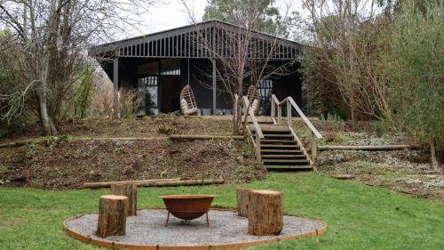 a building with a bench in the middle of a yard at Greenacres in Daylesford