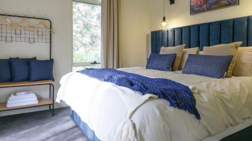 a bedroom with a large bed with a blue headboard at Greenacres in Daylesford